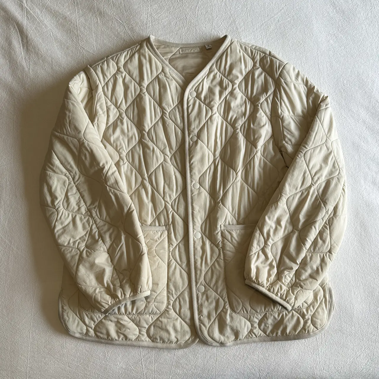 Campera Uniqlo acolchada de color crudo, súper liviana. Para usar en media estación o debajo de sacos en invierno. Talle 13 de niños pero puede ser un XS/S de adultos. 