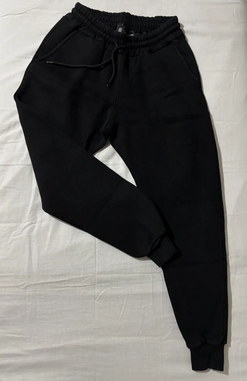 Jogger frizado negro,  tiro medio.  Perfecto para el día a día o para estar en casa. Posee cordón ajustable en la cintura y bolsillos.