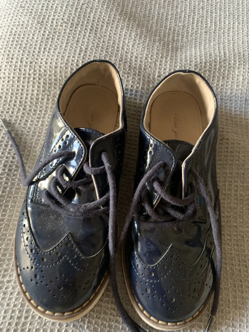 Zapatos de charol azul marino para niña, con detalles brogue y cordones. Ideales para ocasiones especiales.