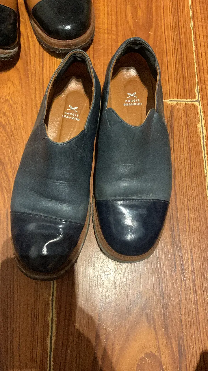 Mocasines de cuero azul marino con puntera brillante y suela marrón. Marca Margie Franzini.