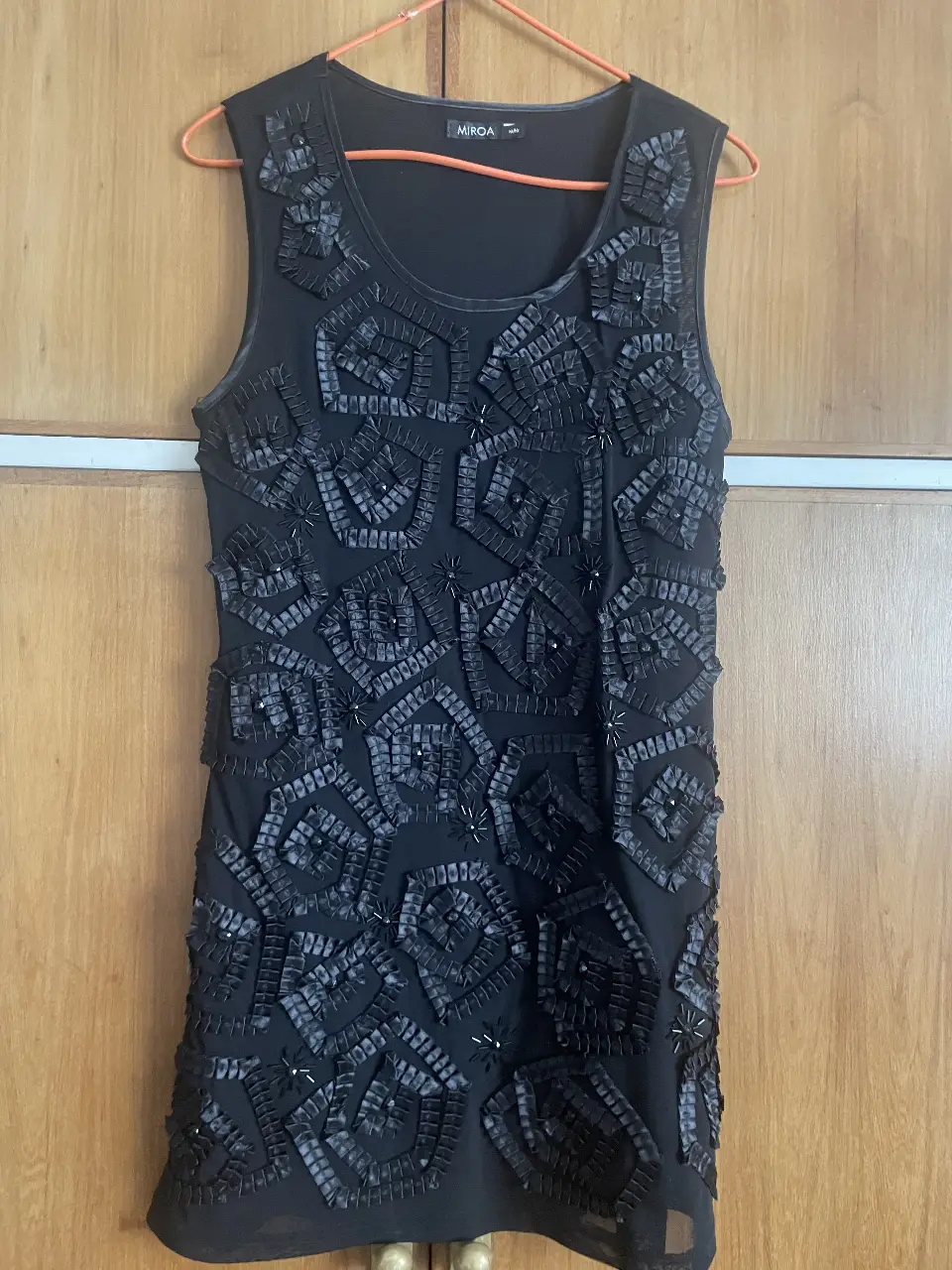 Vestido negro mini transparente con detalles en relieve. Ideal para usar con un body negro para una fiesta o salida nocturna.