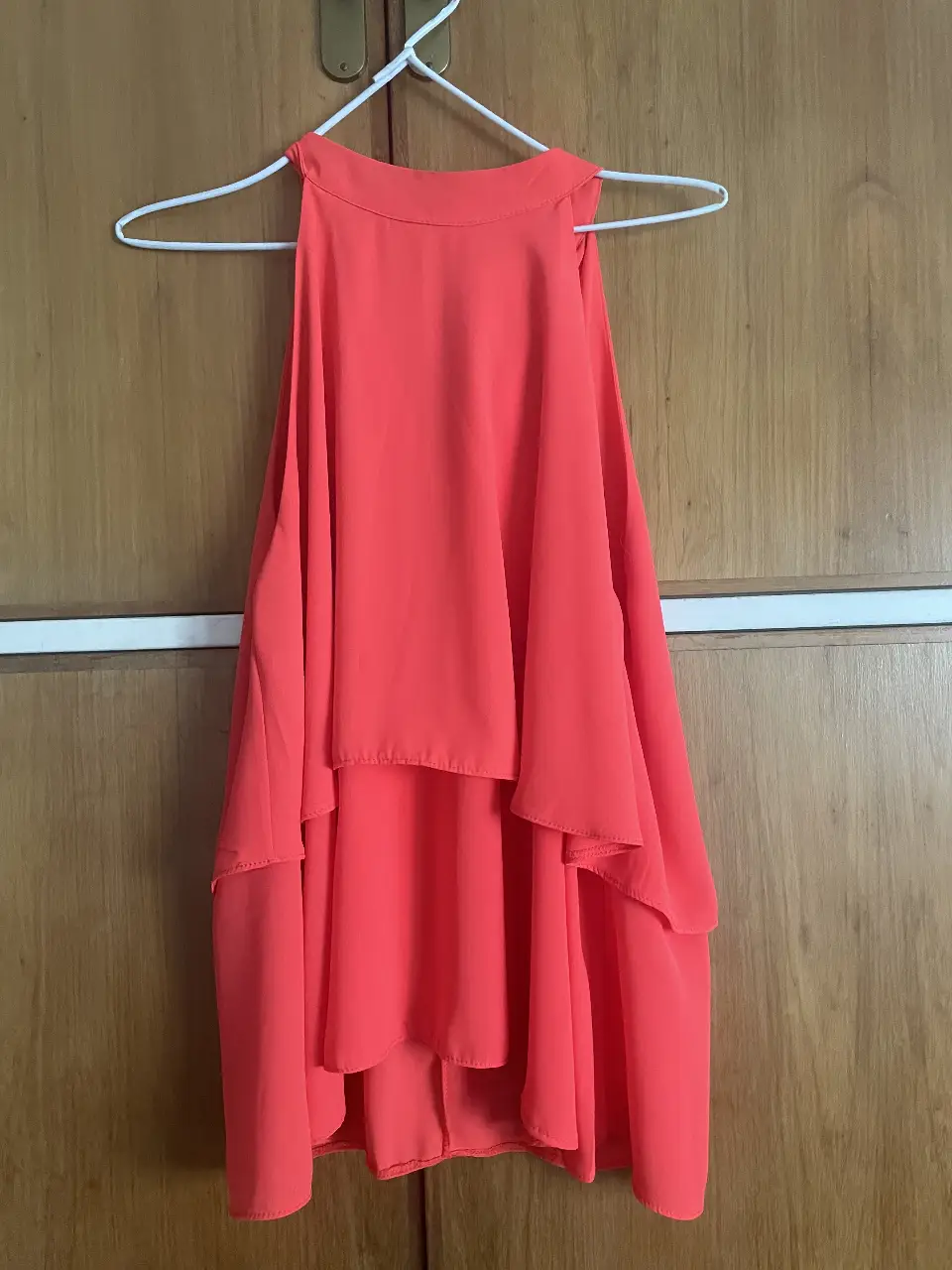 Blusa naranja con diseño de volantes y cuello halter. Ideal para un look fresco y elegante.