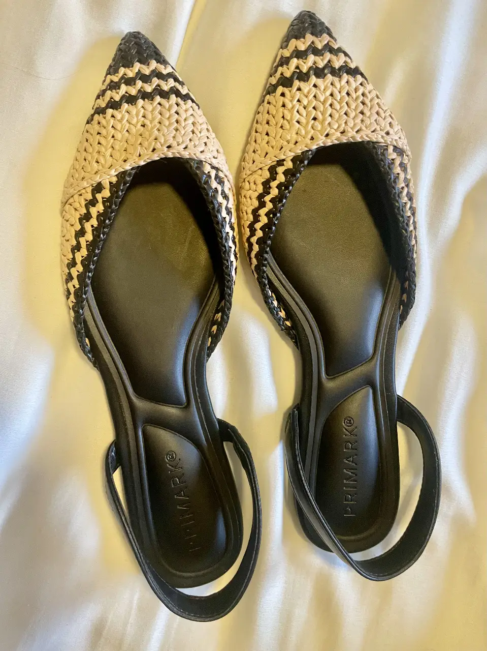 Sandalias planas de mujer, con diseño tejido en color crudo y negro. No tienen uso. Poseen correa en el talón y plantilla negra. Marca Primark.