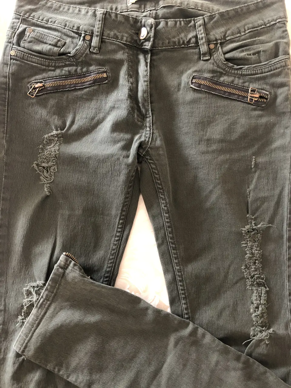 Pantalón de jean recto tiro bajo (40cm de ancho ) de color verde oscuro con detalles de roturas y cierres en los tobillos. Ideal para un look casual y moderno. si bien la etiqueta dice talle 29, yo diría que es un 27 al cuerpo. 