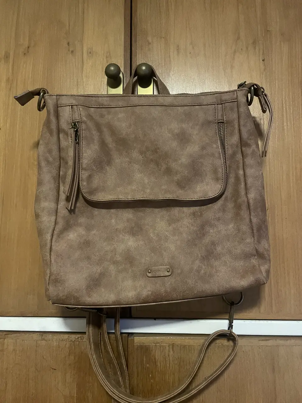 Mochila/cartera (se adapta a ambas opciones) marca Lounge (Chile) de color marrón, ideal para llevar todo lo que necesitas con estilo. Confeccionada en material resistente, cuenta con múltiples compartimentos y un diseño versátil que se adapta a cualquier ocasión. tiene un solo uso. 