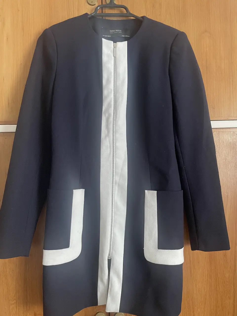 Elegante blazer largo de mujer, color azul marino con detalles en blanco. Cuenta con cierre y bolsillos delanteros. Ideal para un look formal o de trabajo. Impecable estado, lo debo haber usado dos veces. 
