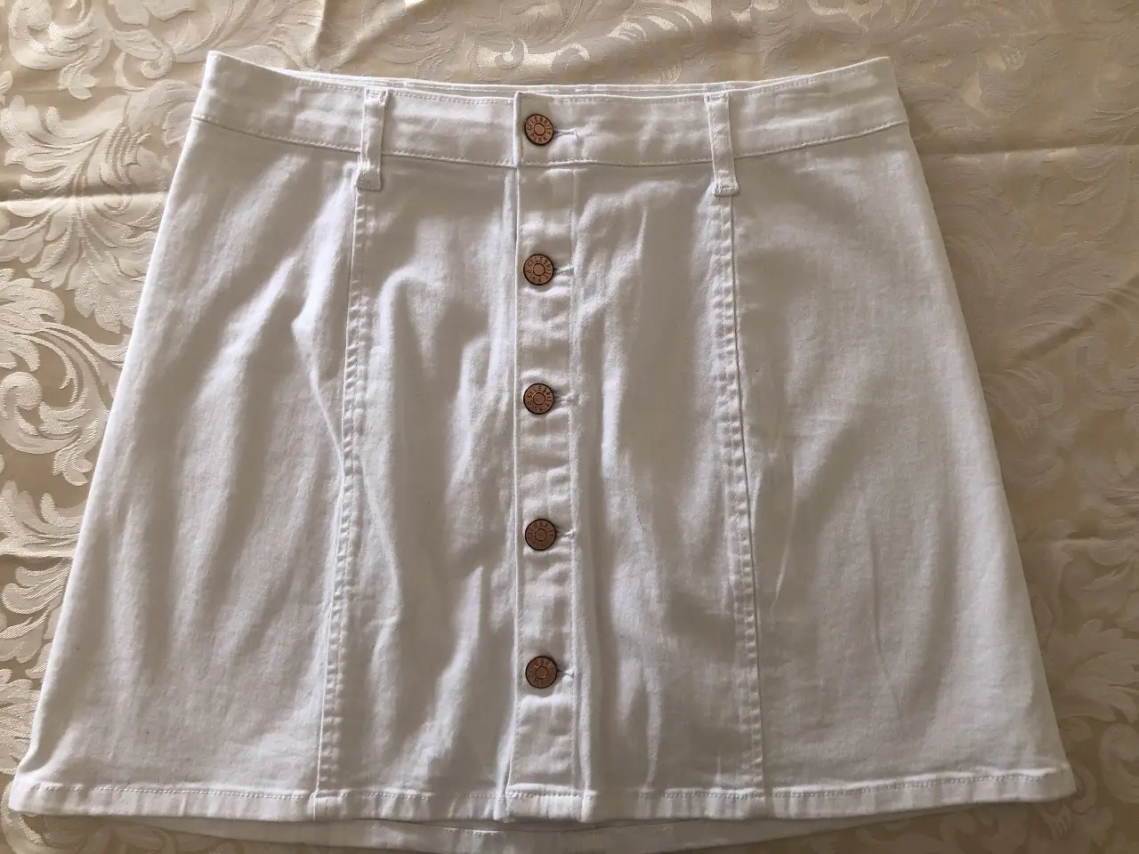 Minifalda de jean blanca con botones frontales. Ideal para un look casual y fresco. tiene 98% algodón y 2% spandex. Tiene 39 cm de cintura/cadera dependiendo a qué alto preferís usarla. Está en excelente estado, muy poco uso. 
