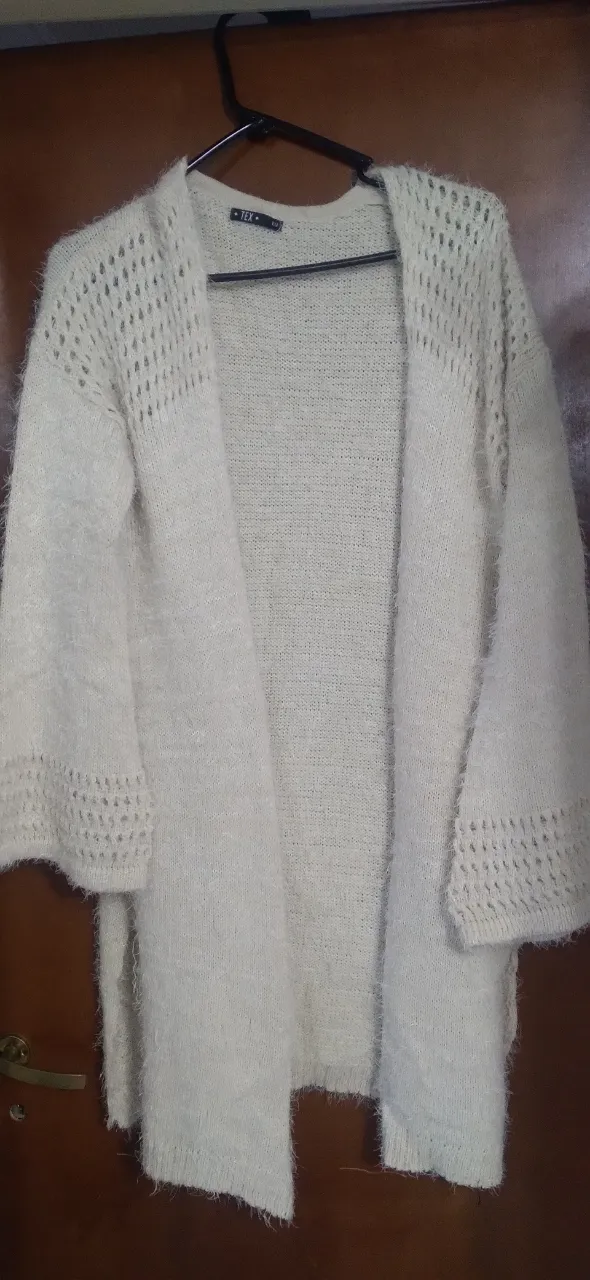 Cardigan abierto de tejido suave y peludo, ideal para abrigar tus outfits. Con mangas 3/4 y detalles calados en los hombros y puños, este cardigan es perfecto para un look casual y cómodo.
