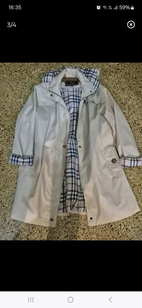 Trench Burberry blanco con forro a cuadros. Ideal para la lluvia y el estilo casual.