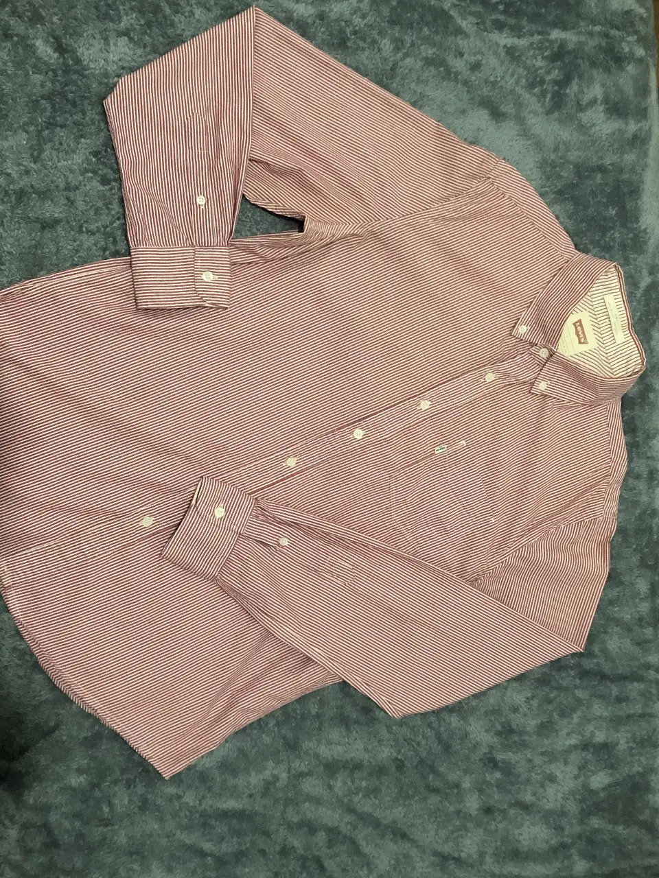 Camisa a rayas rojas y blancas de hombre, ideal para un look casual y moderno. Confeccionada en tela de algodón, esta camisa ofrece comodidad y estilo. Perfecta para usar en cualquier ocasión.