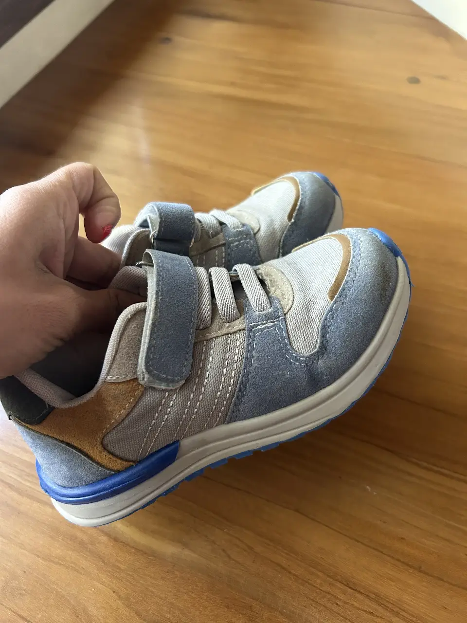 Zapatillas deportivas para niños, con cierre de velcro. Color azul y gris, con detalles en marrón y azul. Talle 28.