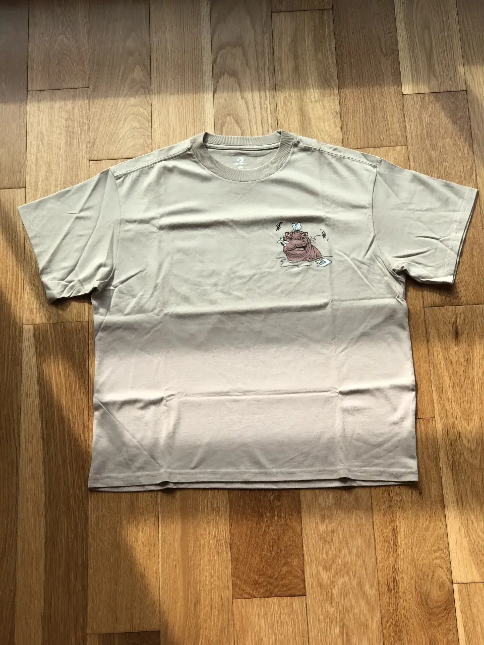 Remera oversize Converse de hombre, color crudo con estampado de un hipopótamo en el frente y la frase "We'll get there together" en la espalda. Ideal para un look casual y cómodo. (talle S pero parece un L)