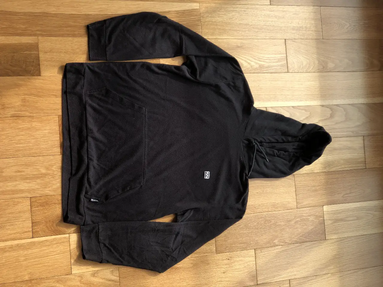 Buzo canguro negro de la marca Billabong, con capucha y bolsillo frontal. Ideal para un look casual y cómodo.