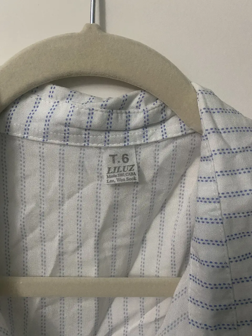 Blusa de mujer a rayas verticales blancas y azules, con detalle de volados en la espalda y cuello. Talle 6.