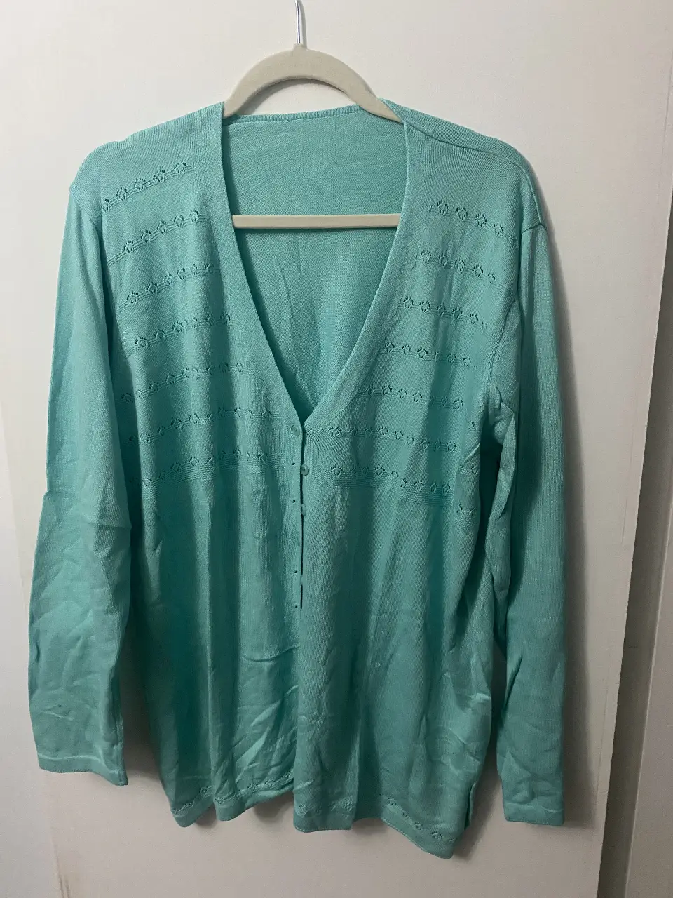 Cardigan de mujer en color verde agua, con cuello en V y botones. Diseño con detalles calados en la parte superior y en el borde inferior. Ideal para un look casual y cómodo.