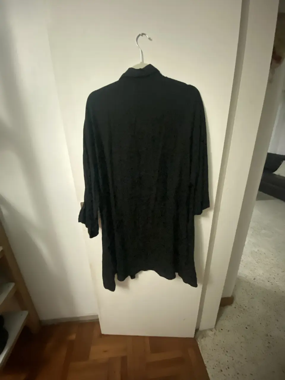 Camisa negra de manga larga, ideal para un look casual y versátil. Confeccionada en un tejido suave y fluido, perfecta para combinar con diferentes outfits.