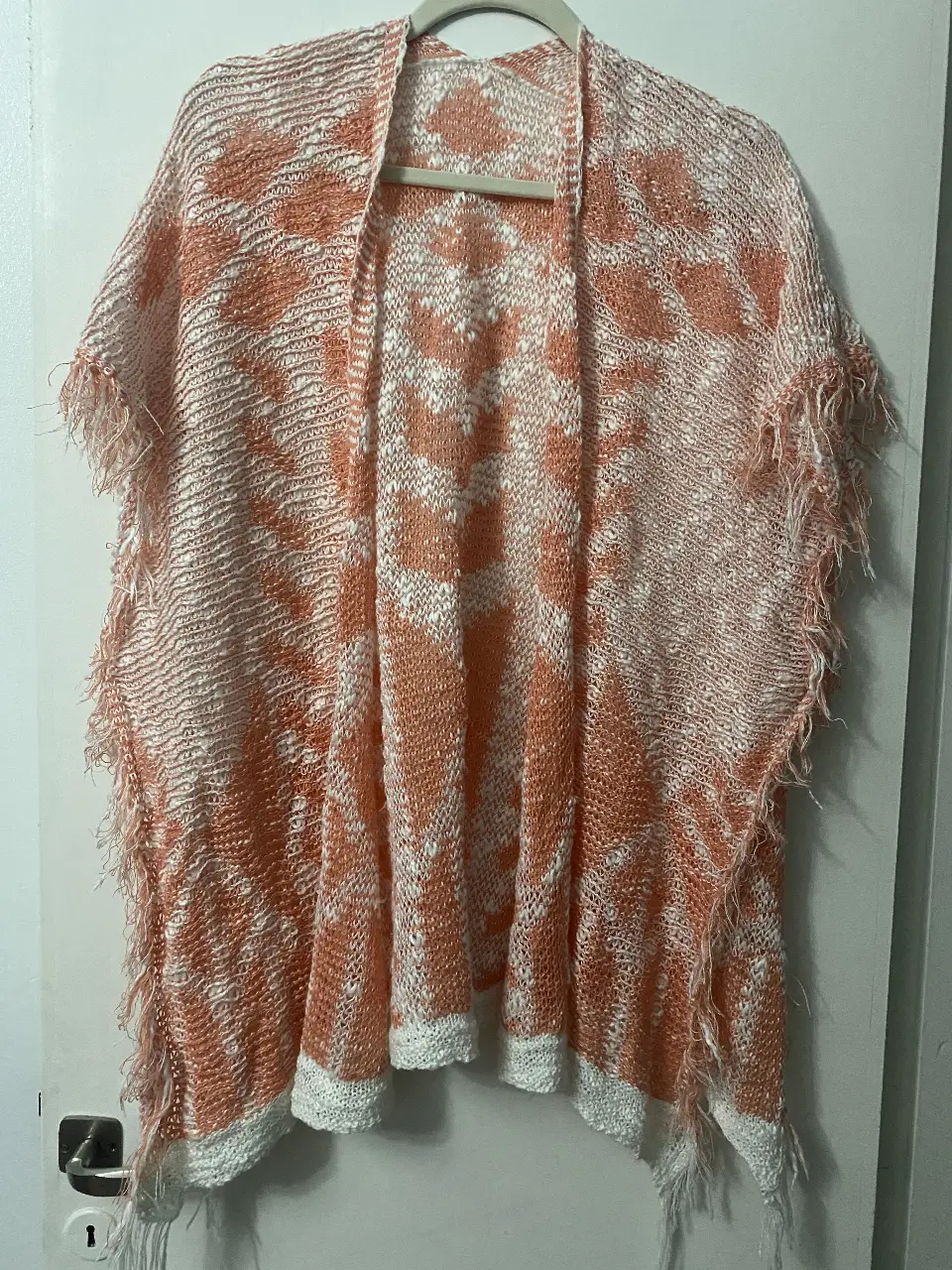 Kimono tejido con diseño floral en tonos naranja y blanco, ideal para un look bohemio y casual. Perfecto para usar en primavera/verano.