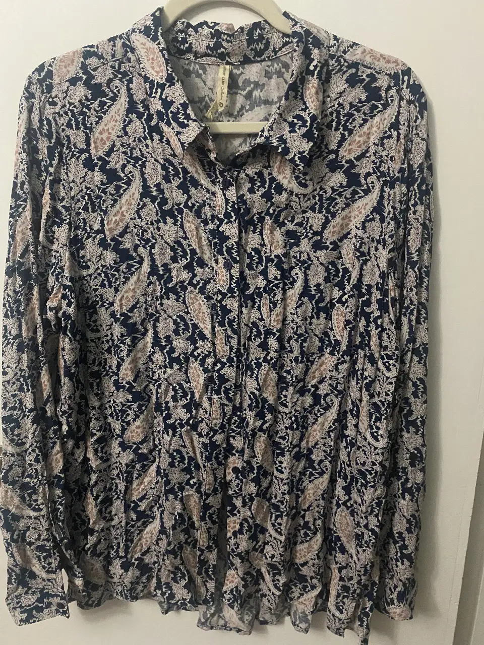 Camisa estampada con diseño de paisley en tonos azul marino y marrón. Cuello camisero y cierre frontal con botones. Ideal para un look casual y con estilo.