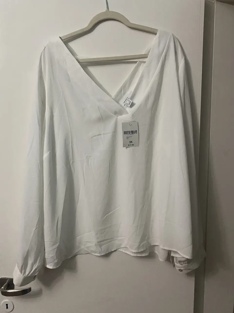 Blusa blanca de manga larga con cuello en V, ideal para un look elegante y versátil. Talle 3X.