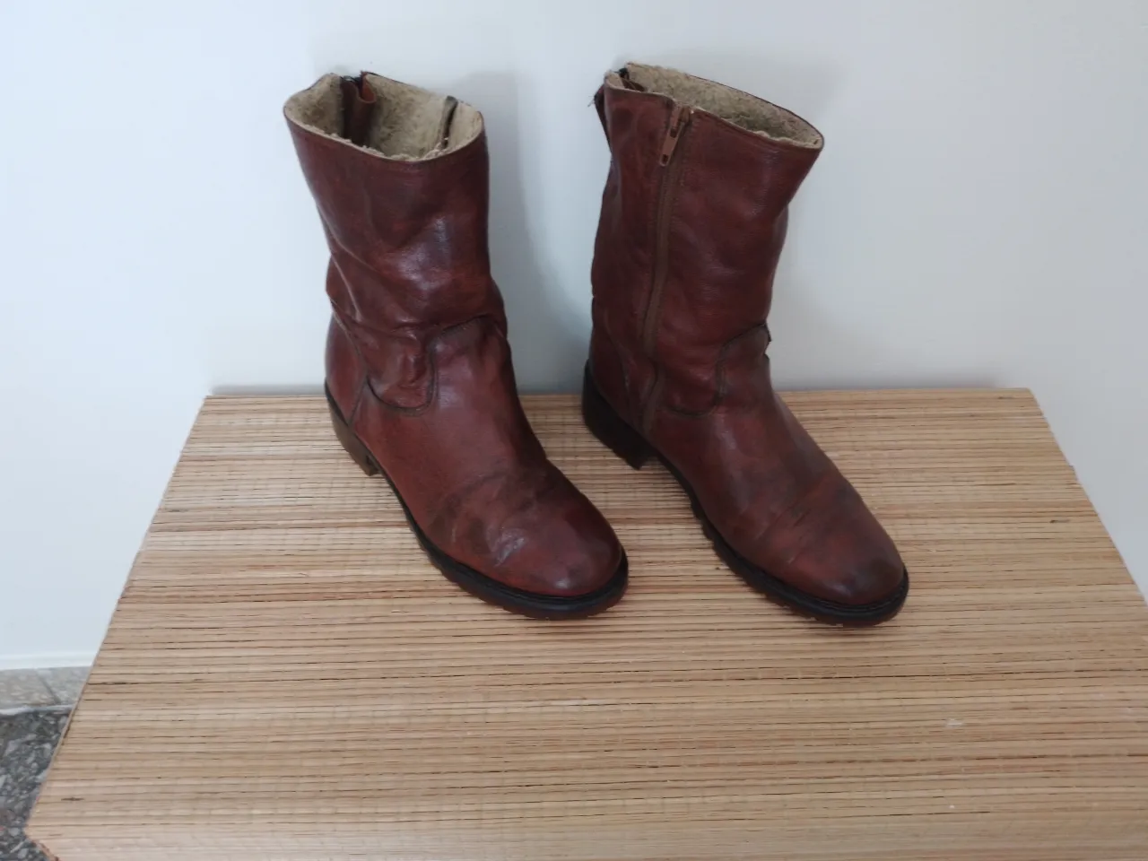 Botas de cuero marrones con forro interior de peluche. Tienen cierre lateral y por detras, suela gruesa ,cuero grueso con desgaste interior en los talones.