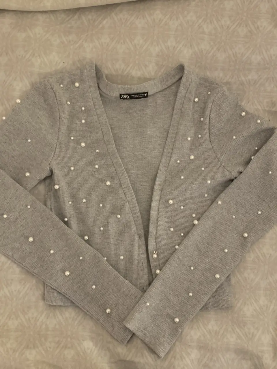 Cardigan gris de Zara con detalles de perlas. Ideal para un look elegante y sofisticado.