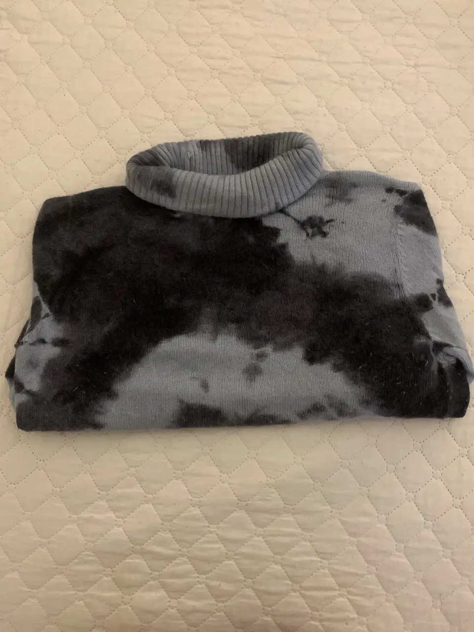 Sweater de cuello alto con diseño tie-dye en tonos azules y celestes.Ideal para un look casual y moderno.