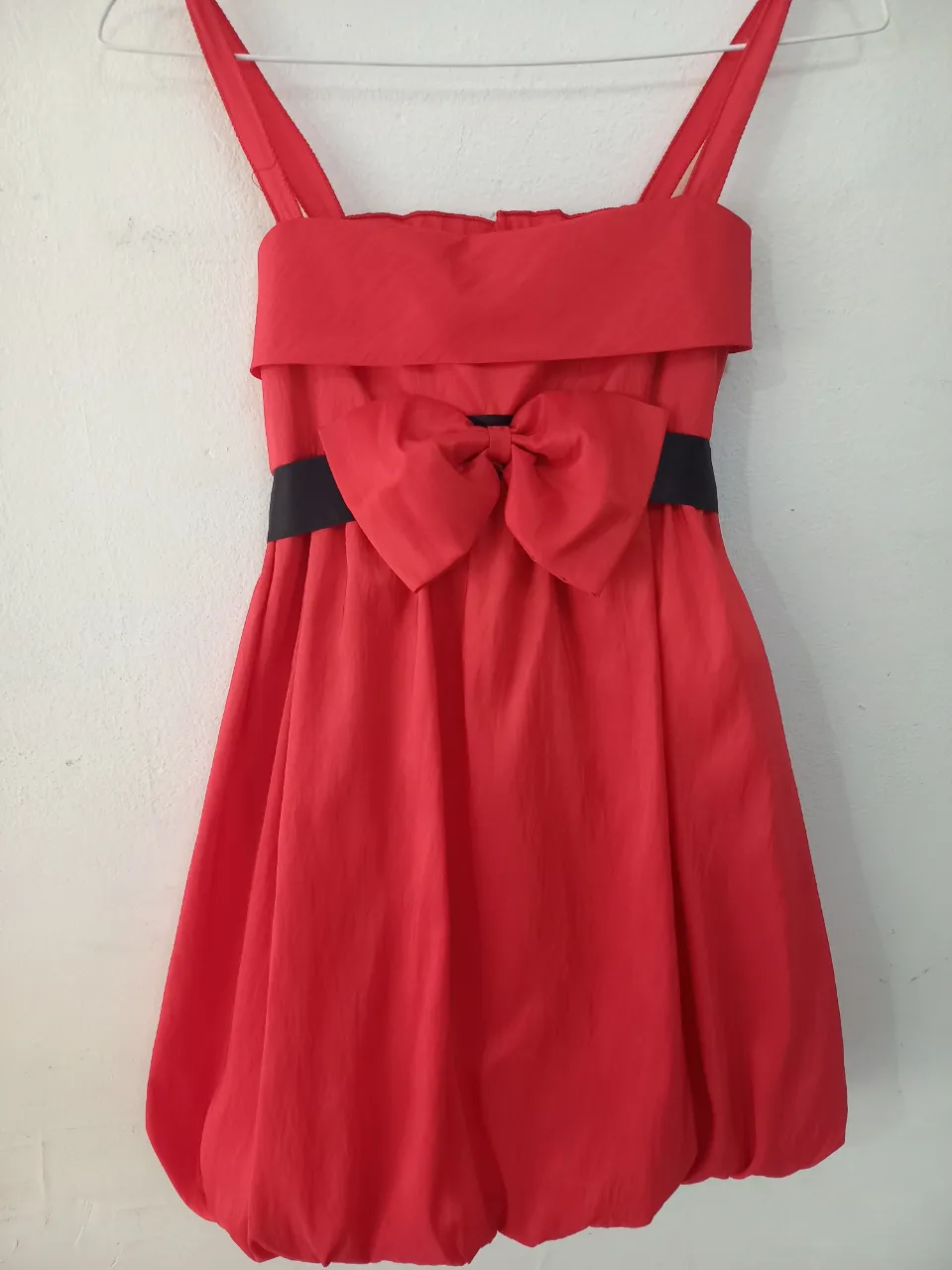Vestido rojo espectacular con moño grande en el frente y cinturón negro de raso.  Falda tipo globo y espalda alta elastizada.  Ideal para fiestas o eventos especiales.