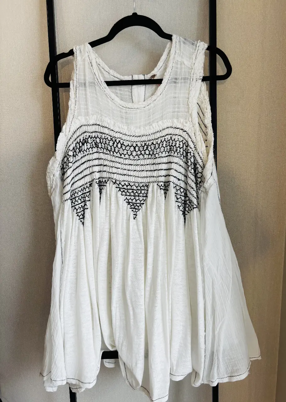 Blusa blanca con detalles bordados en negro, estilo boho. Ideal para un look casual y fresco.