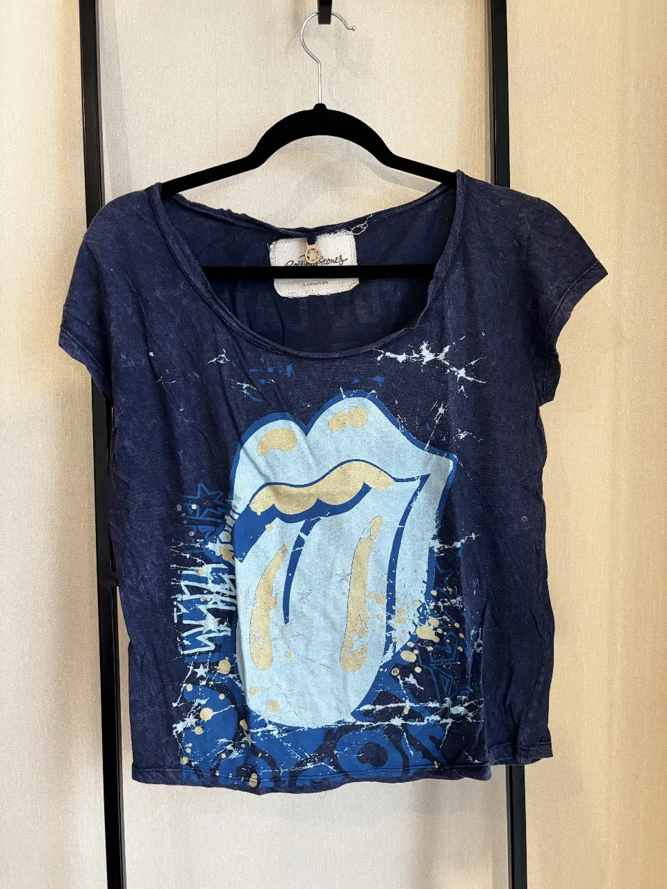 Remera de manga corta azul marino con estampado del logo de The Rolling Stones en la parte delantera. En la espalda, lleva la frase "IF YOU CAN'T ROCK ME... THE ROLLING STONES WILL" en color blanco. Ideal para un look casual y con onda rockera.