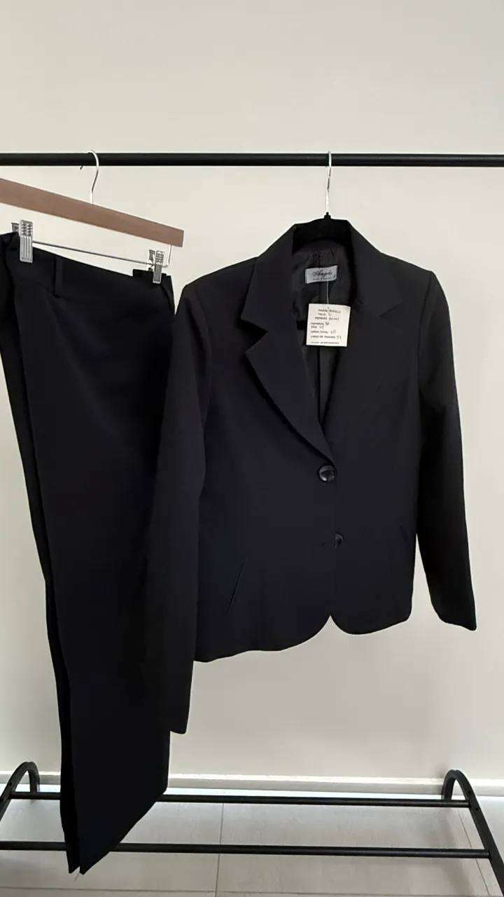 Traje de dos piezas negro, compuesto por saco y pantalón. El saco tiene cuello solapa, dos botones al frente y mangas largas. El pantalón es recto, con cierre y dos botones en la cintura. Va para un talle xs o s. medidas en las fotos. 70%lana y 30%viscosa