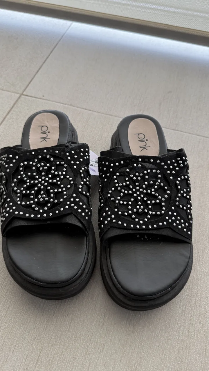 Ojotas negras con plataforma. Tienen tiras anchas con diseño calado y tachas plateadas. talle 37, 24 cm de plantilla. usadas en buen estado 