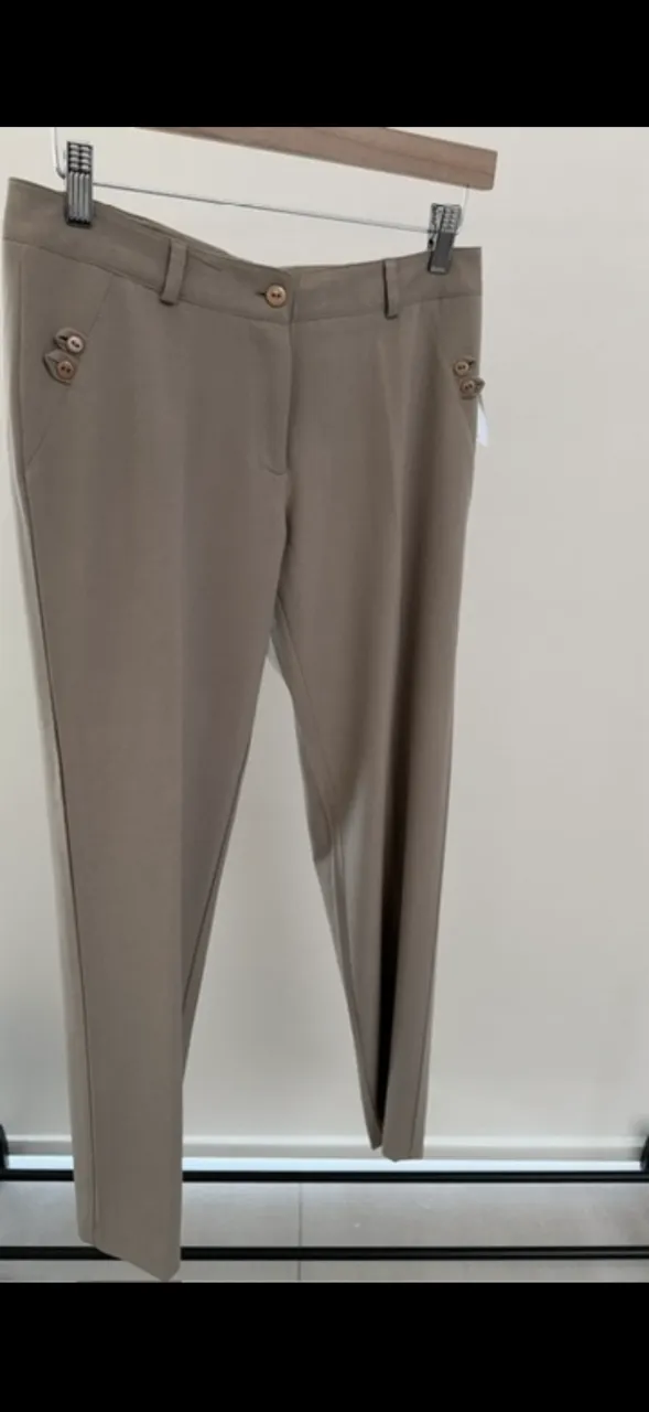 Pantalón de vestir color beige con detalles de botones en los bolsillos delanteros. Cierre y botón en la cintura.
marca etam, talle 1. medidas en la publicación 
