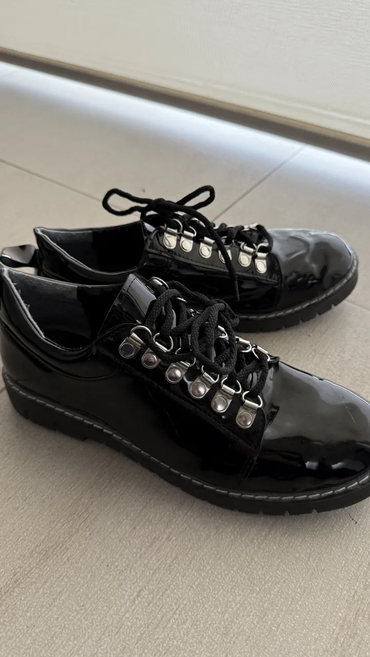 Zapatos acordonados  negros de charol con cordones y ojales metálicos. Suela gruesa con diseño. Talle 40, plantilla de 26cm