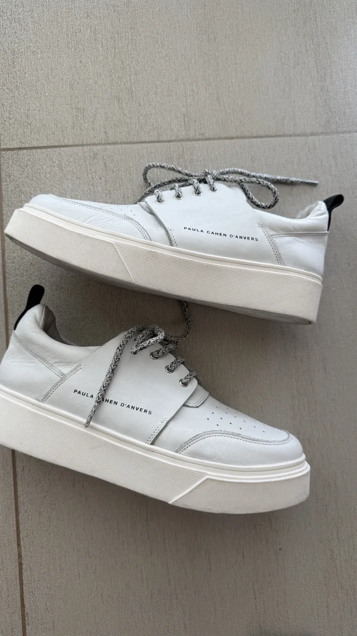Zapatillas urbanas de cuero blanco tiza con cordones grises y suela blanca. Detalle de perforaciones en la punta y logo de la marca en los laterales.
Marca Paula Cahen D’anvers Talle 40 horma grande, son 26,5 cm de plantilla 