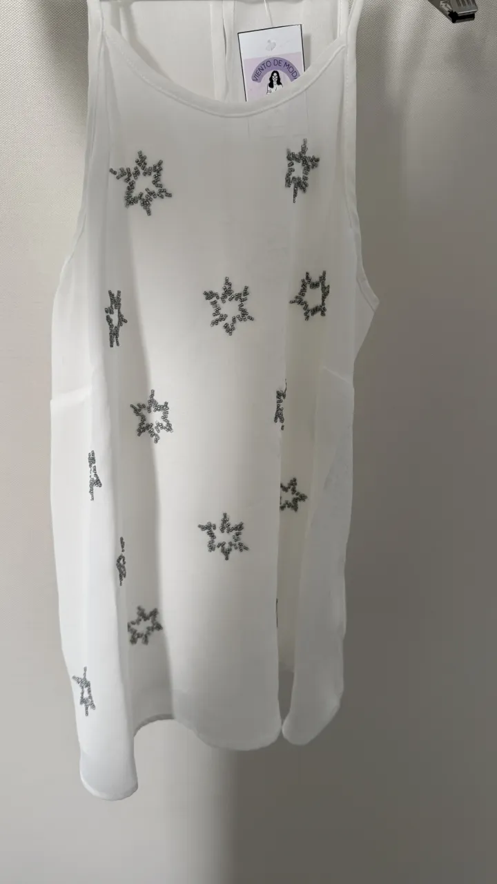Musculosa blanca con detalles de estrellas bordadas en plateado. Ideal para un look canchero y fresco.

medidas
sisa 45, largo 64