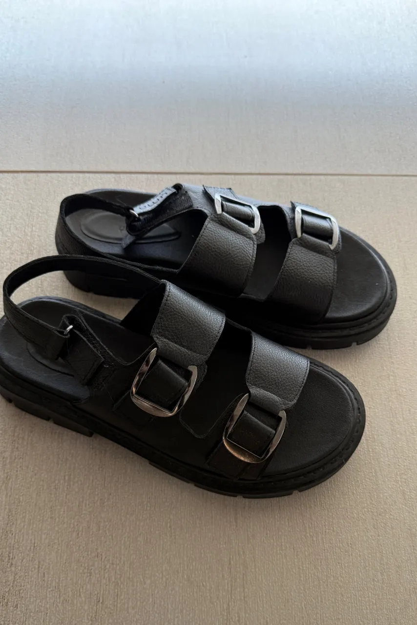 Sandalias negras de cuero con hebillas plateadas y suela gruesa. Perfectas para un look casual y moderno.
Marca UMA. Talle 40. 26 cm de plantilla. 100% cuero