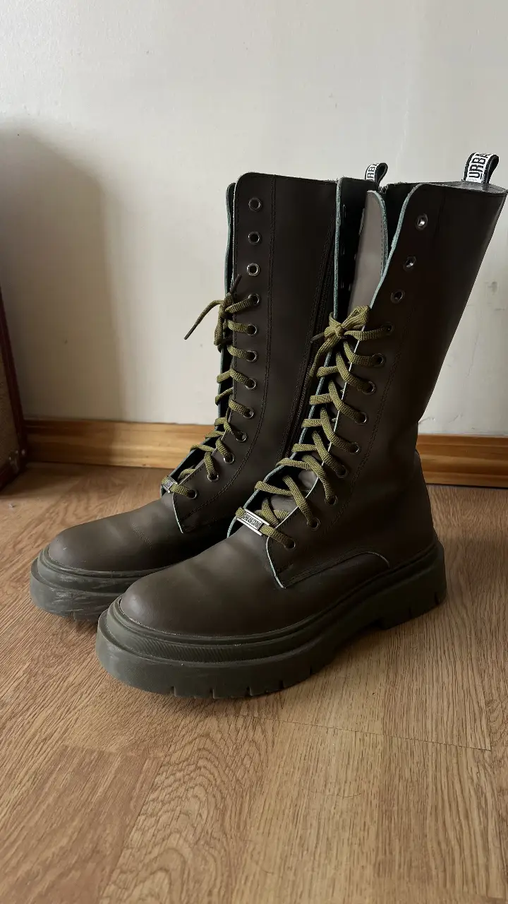 Botas de caña alta color verde militar con cordones y cierre lateral. Ideales para un look urbano y moderno.