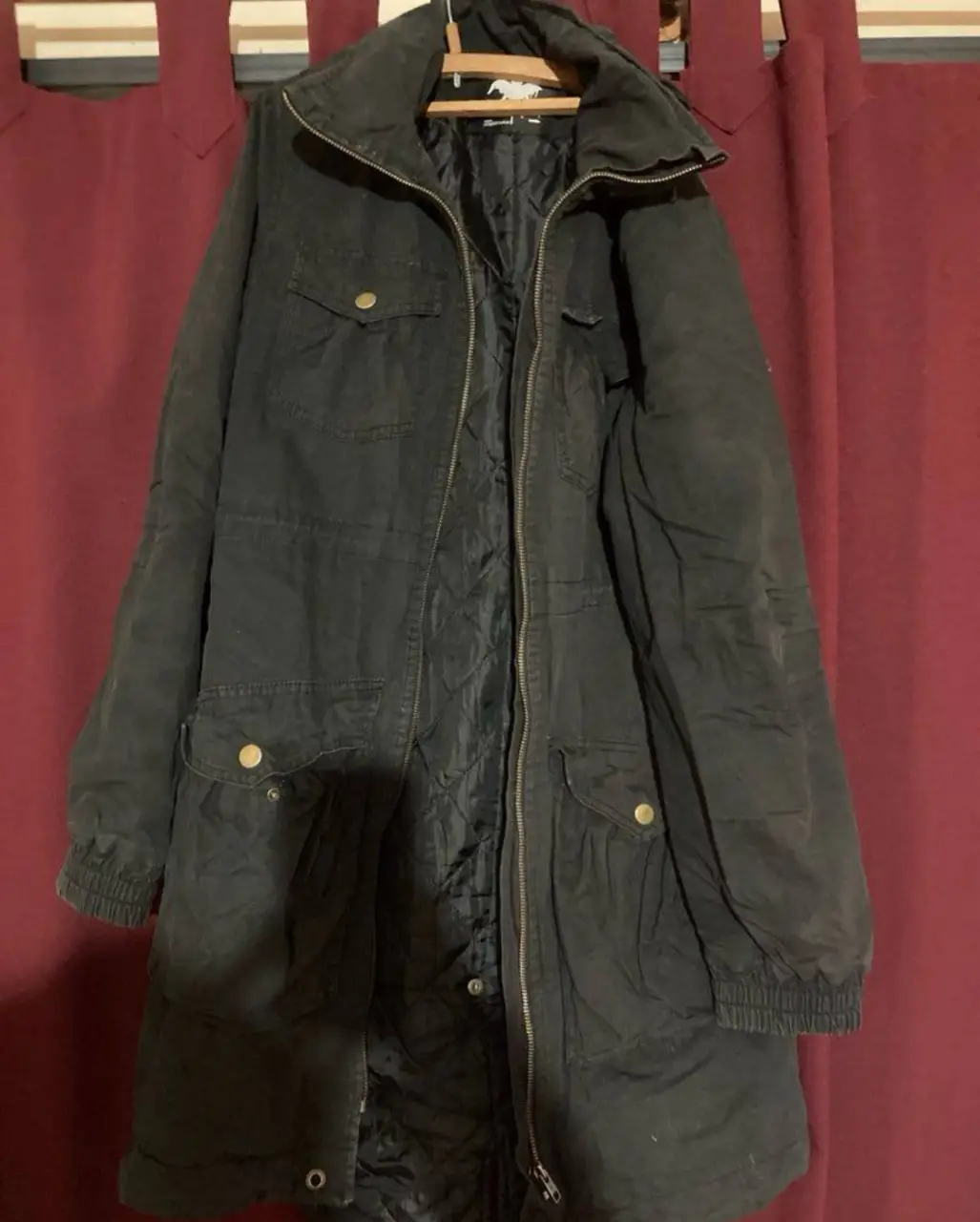 Campera larga negra con cierre y bolsillos. Ideal para el invierno, con forro interior acolchado.
