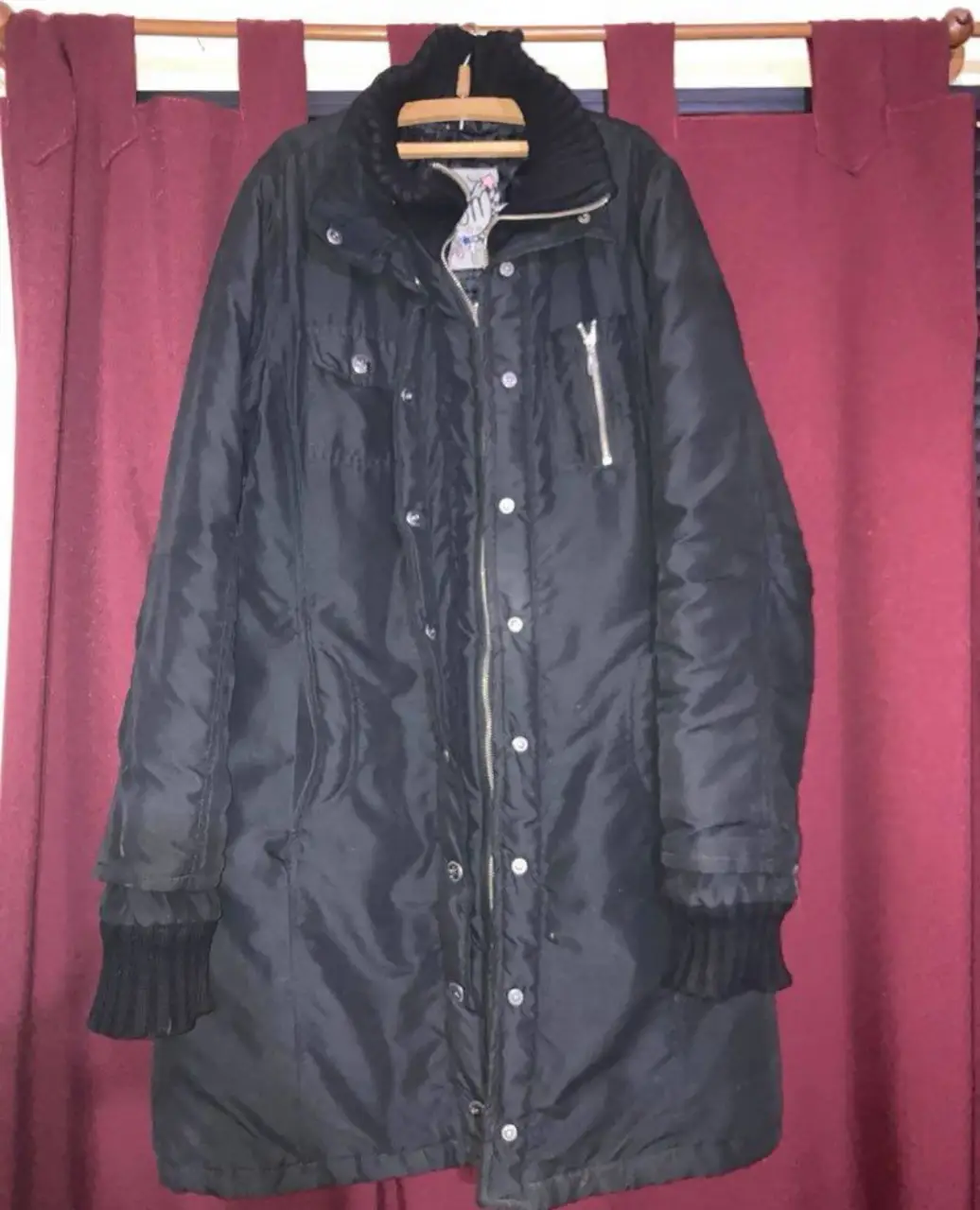 Sobretodo largo negro, ideal para el invierno. Posee cierre y botones, con detalles de puños tejidos. Cuello alto con tejido.