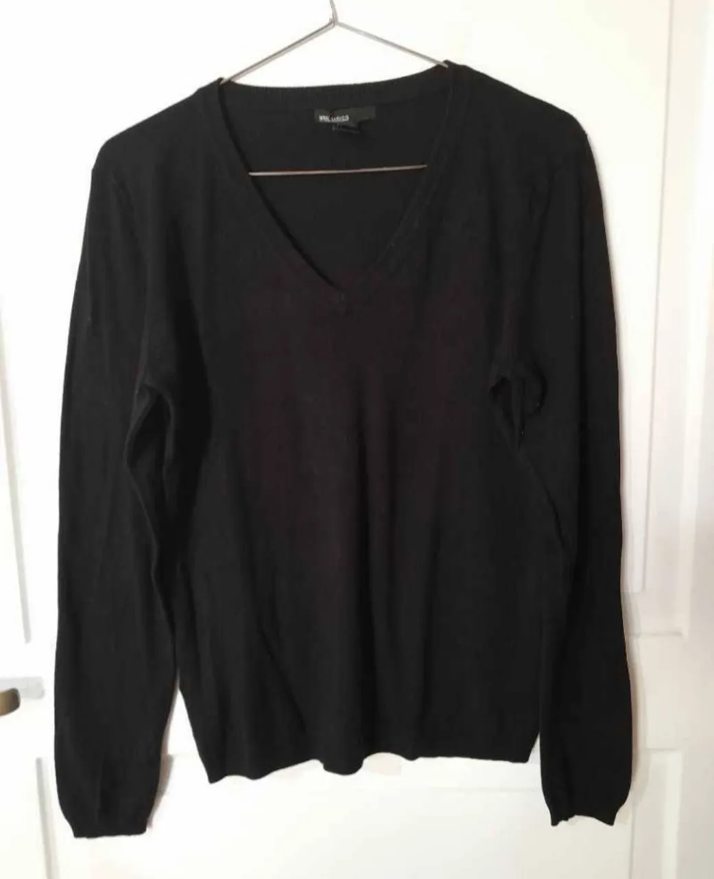 Sweater negro de cuello en V, manga larga. Un básico ideal para cualquier ocasión.
