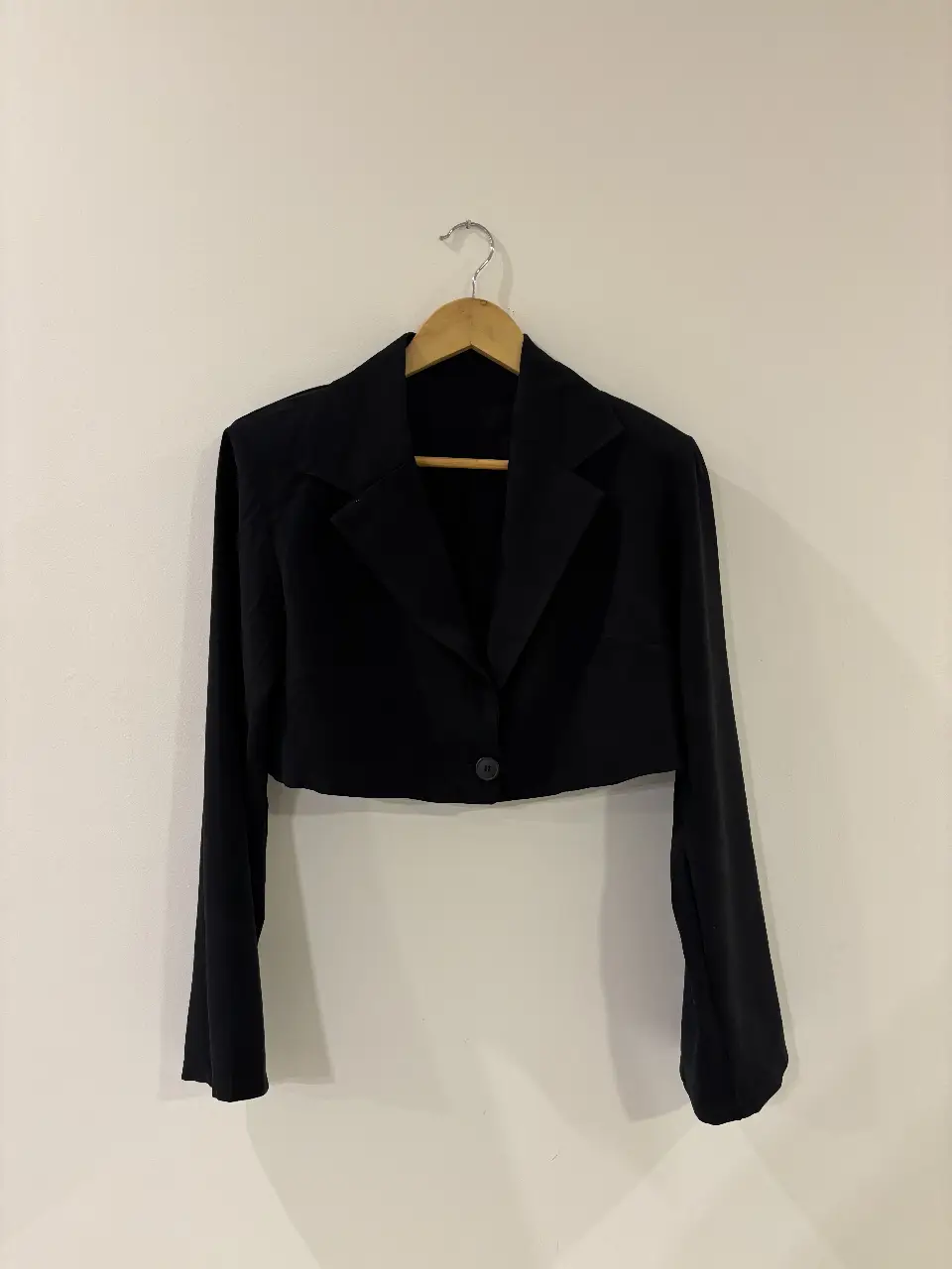 Blazer crop negro, con prequeñas hombreras.
