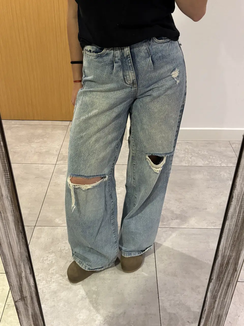 Jeans de mujer, tiro alto, con roturas en las rodillas. Corte ancho, estilo wide leg.