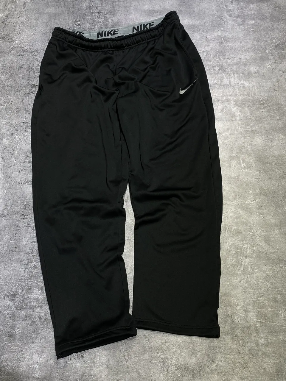 Pantalón deportivo negro de hombre, con logo Nike en la cintura. Ideal para entrenar o para un look casual y cómodo.