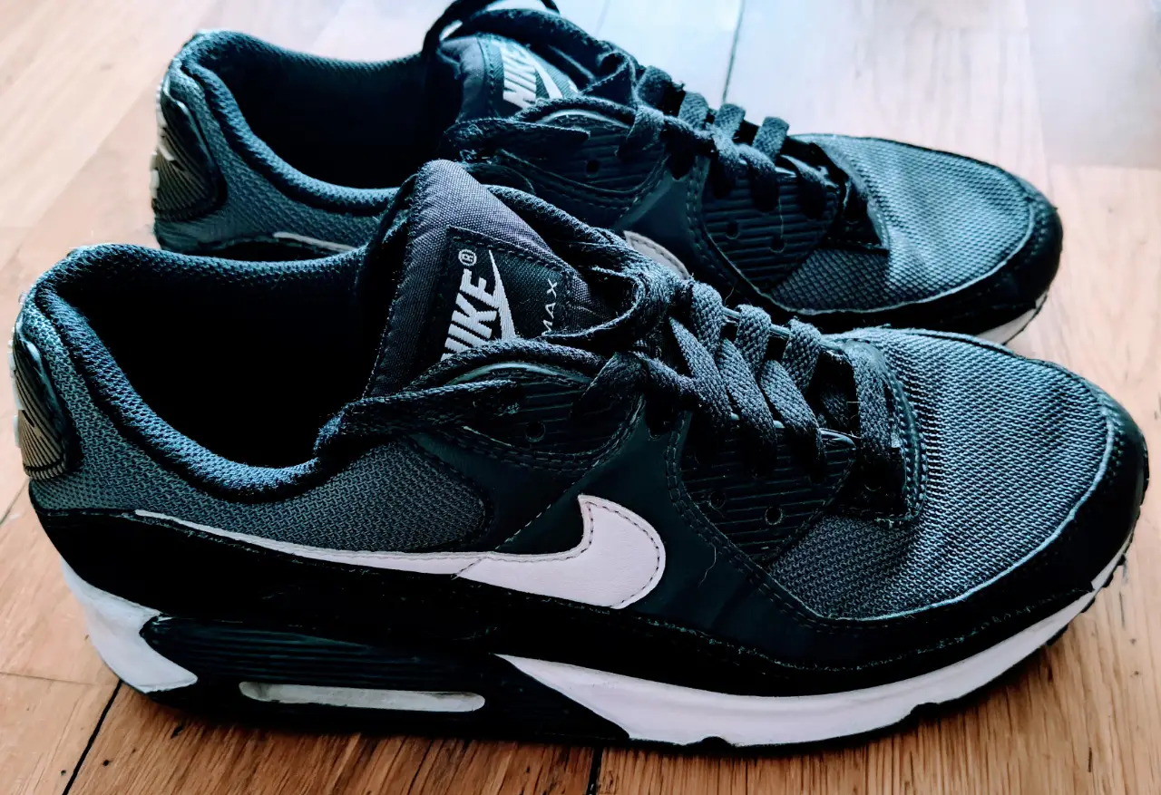 Zapatillas Nike Air Max 90 en color negro con detalles en blanco. Diseño clásico y atemporal, ideales para uso diario y actividades deportivas.