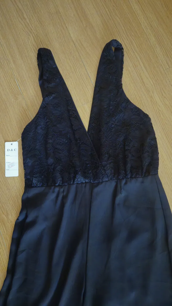 Mono largo negro con detalles de encaje en la parte superior. Ideal para eventos formales o fiestas.