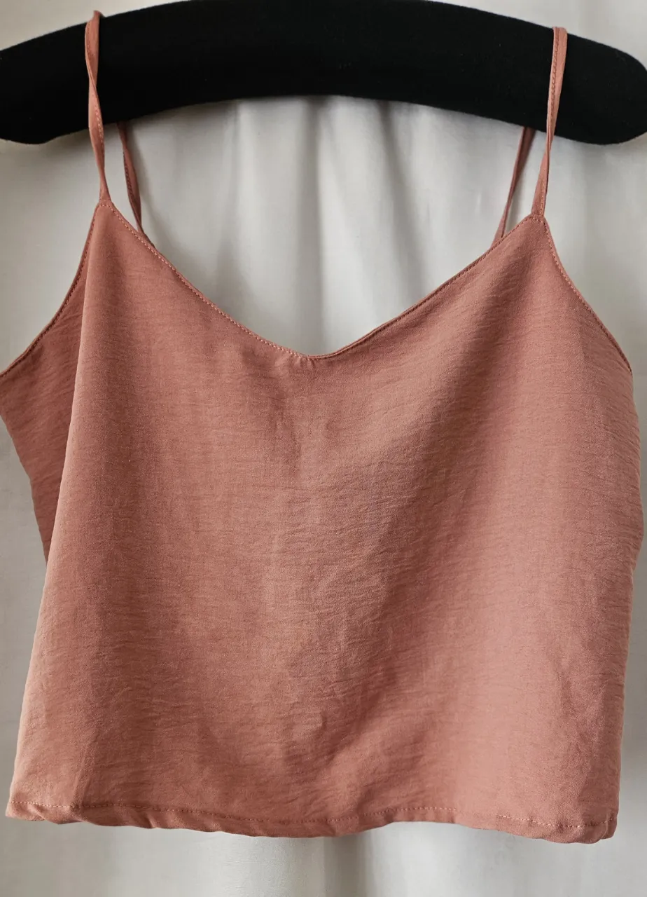 Top de mujer, color rosa, con tirantes finos y espalda descubierta. Ideal para un look fresco y moderno.