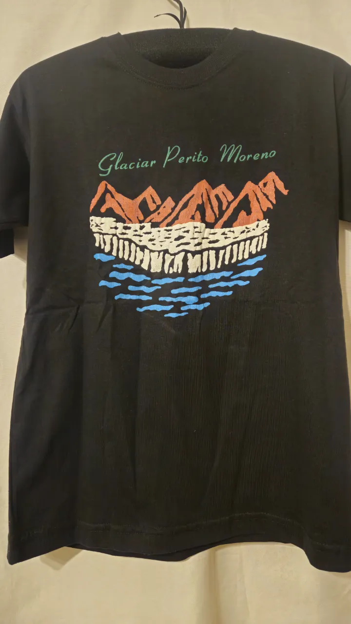 Remera negra con estampado del glaciar Perito Moreno. Diseño colorido y llamativo, ideal para amantes de la naturaleza y el turismo en Argentina. Talle S.