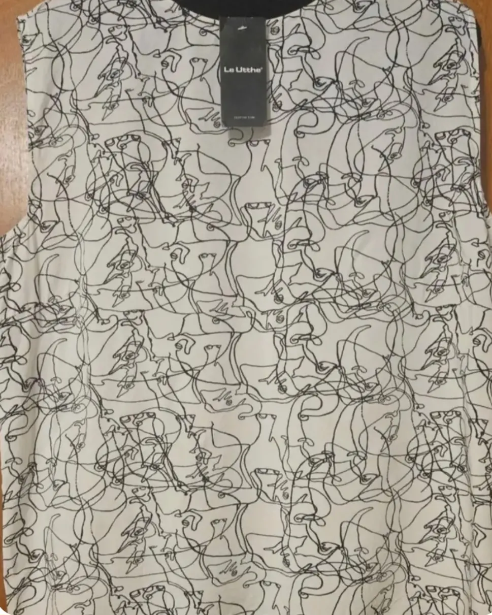 Blusa de mujer con estampado abstracto en blanco y negro. Diseño con cuello redondo y sin mangas, ideal para un look moderno y versátil.