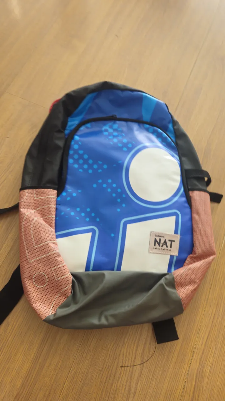 Mochila escolar azul con detalles blancos y naranjas. Cuenta con un diseño moderno y un logo en la parte frontal. Ideal para llevar libros y útiles. Impermeable 40*39*15 cm.
