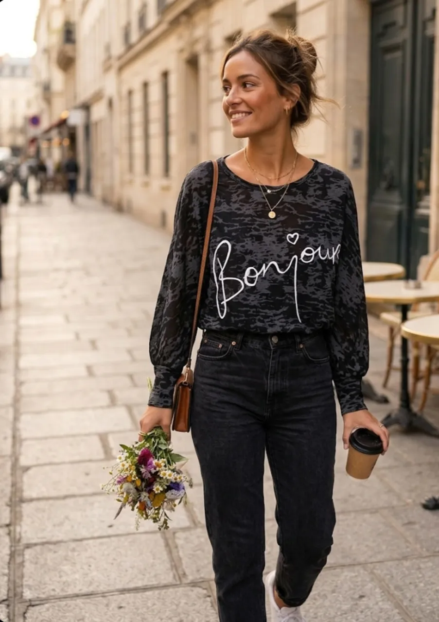 Remera manga larga estampada con la palabra "bonjour" en blanco. Posee un estampado abstracto en tonos de gris y negro.